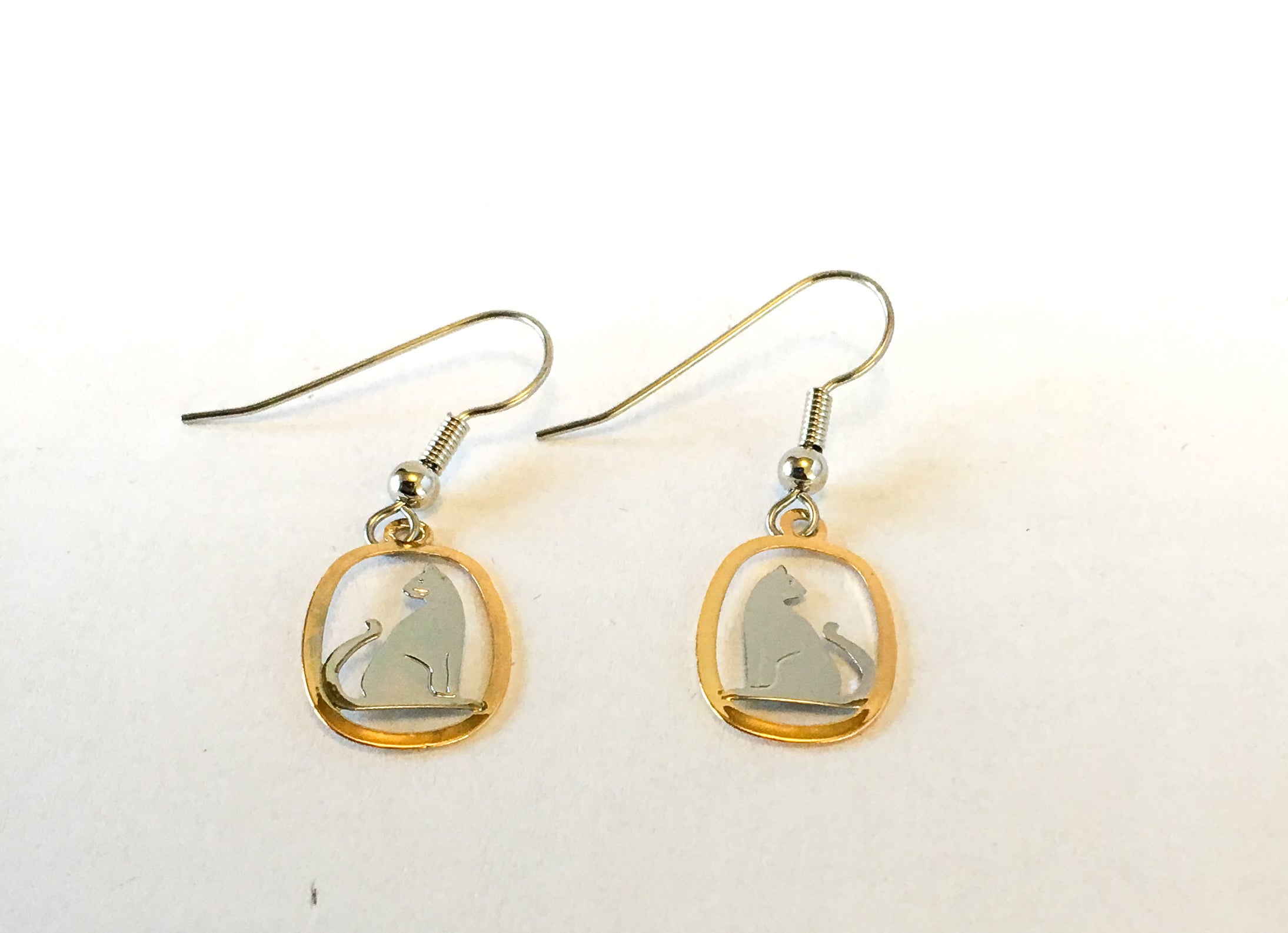 Silver and gold cat earrings facing out