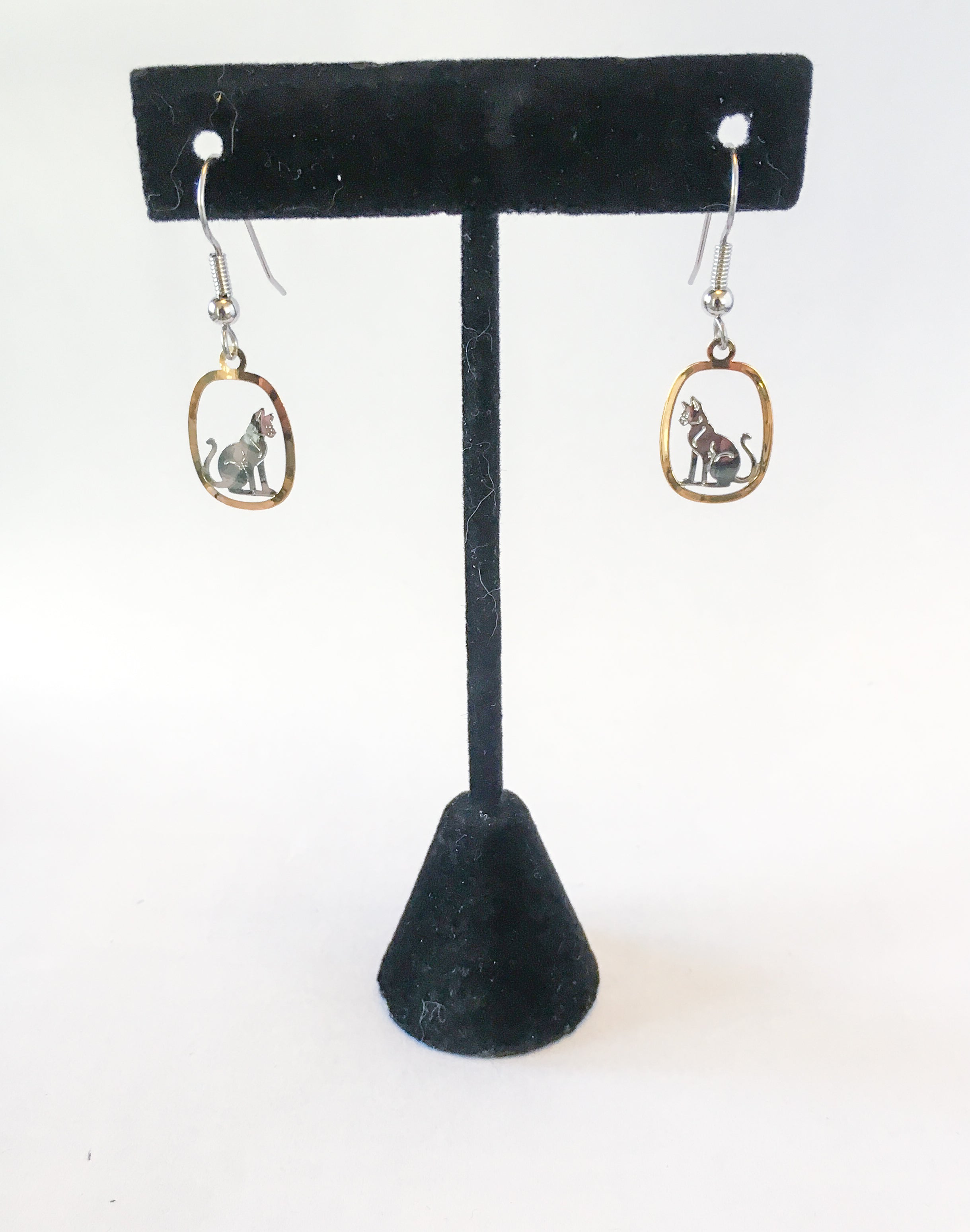 silver and gold cat earrings hang